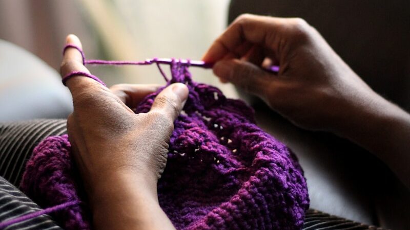 woman sewing purple textile